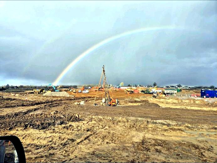 Cable percussion rig on a site with a rainbow behind it